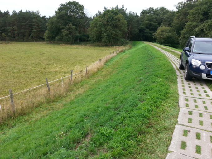 Ein Auto fährt auf einem Deichweg, nachdem eine geöffnete Stelle im Deich im Jahr 2015 wieder geschlossen wurde.
